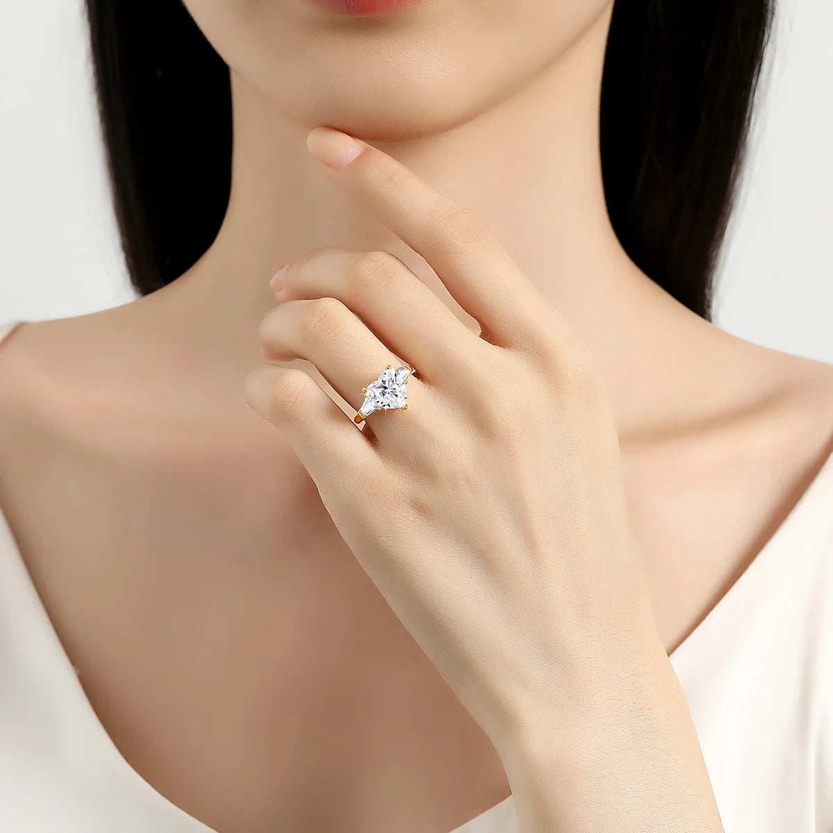 Bague de fiançailles cœur 3ct triple diamants Irit en or jaune 14K lumineux portée au doigt d'une femme vue de face.
