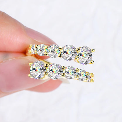 Bague de fiançailles dix pierres en argent 925 plaqué or jaune et diamants éclatants montrée entre les doigts d'une femme vue de proche.