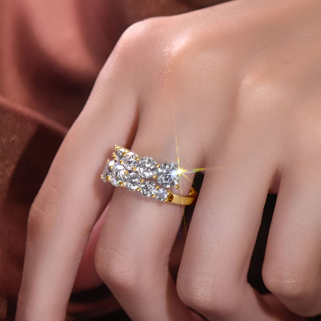 Bague de fiançailles dix pierres en argent 925 plaqué or jaune et diamants scintillants portée au doigt d'une femme vue de proche.
