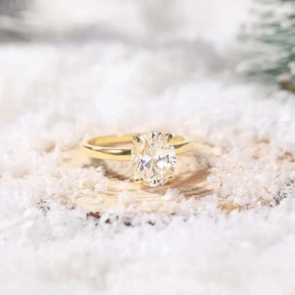 Bague de fiançailles en or 14K vue de loin sur surface cotonneuse, design raffiné avec zircon cubique et plaquage or