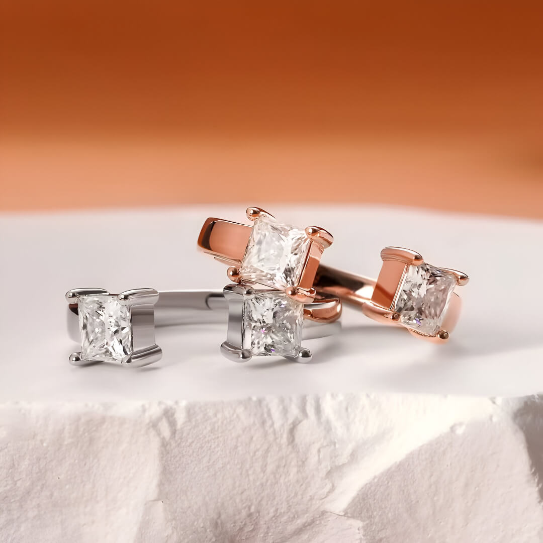 Variantes blanche et rosé de la bague de fiançailles ouverte Nivara en argent 925 plaqué or blanc et plaqué or rosé serties de diamants taille princesse vue de face.