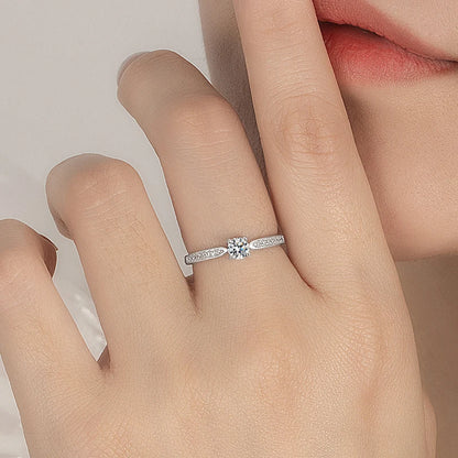 Bague de fiançailles en or blanc platiné et diamant synthétique et naturel portée au doigt d'une femme.