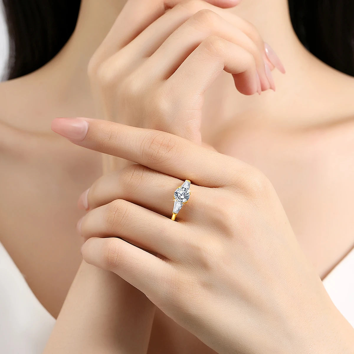Variante 1CT de la bague de fiançailles triple diamants Moriah en or jaune 14K chaleureux portée au doigt d'une femme vue de face.