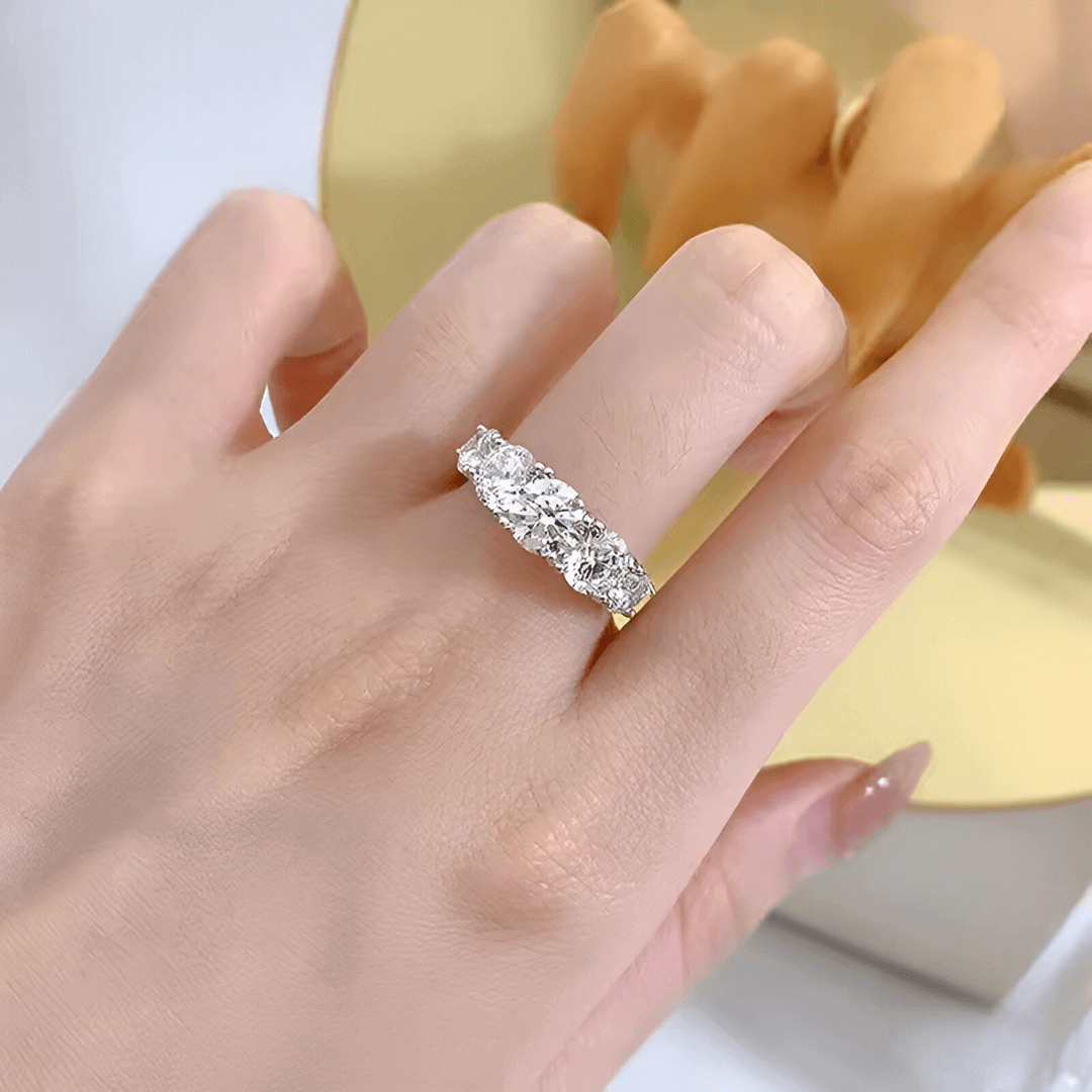 Bague de promesse sept pierres graduées Daphné en argent 925 plaqué platine et diamants portée au doigt d'une femme vue du dessus.