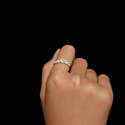 Bague de promesse sept pierres graduées Daphné en argent sterling 925 plaqué platine et diamants portée au doigt d'une femme vue de face.