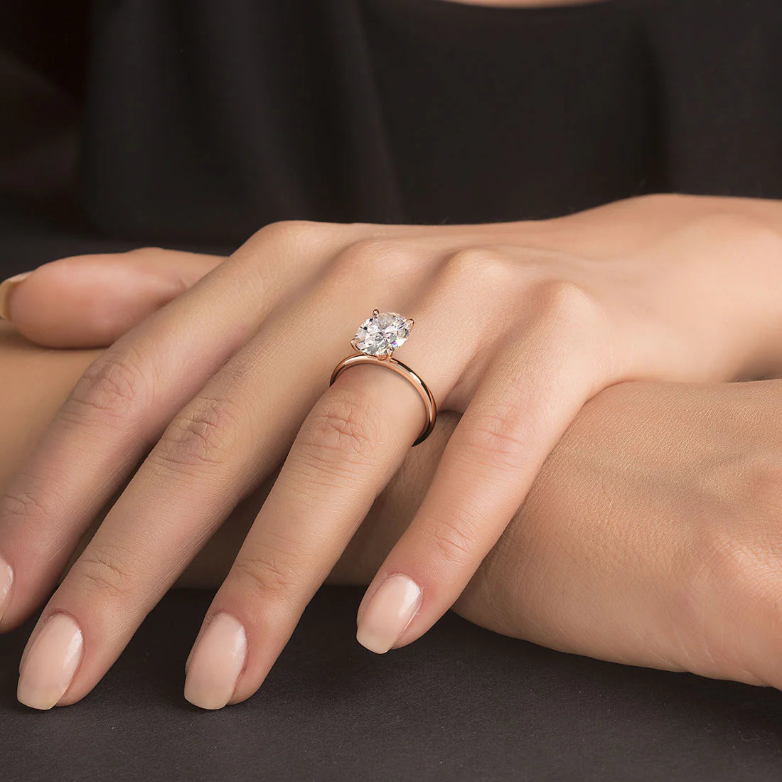 Bague d'engagement fine diamant ovale 3ct Mira en argent 925 plaqué or rosé raffiné portée au doigt d'une femme vue de proche.