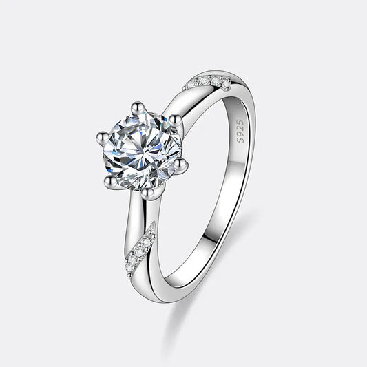 Bague diamant solitaire serti six griffes Farah en argent 925 plaqué or blanc sur fond blanc cassé.
