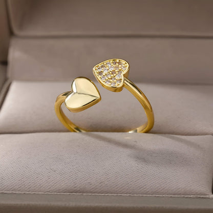 Bague double cœur doré Lumira en acier inoxydable plaqué or jaune 18K chaleureux et petits diamants ronds rangée dans son écrin.