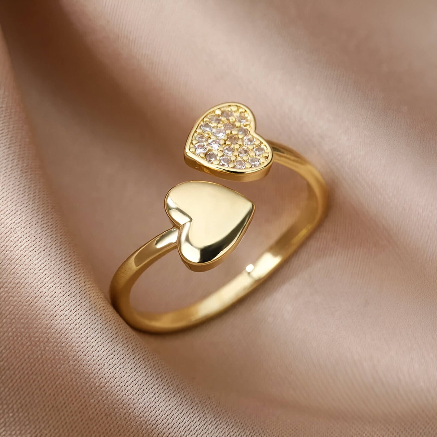 Bague double cœur doré Lumira en acier plaqué or jaune 18K et petits diamants ronds vue de proche.