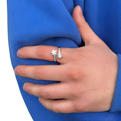 Bague double étoiles ajustatble en acier plaqué or blanc 18K discret et diamants portée au doigt d'une femme vue de face.