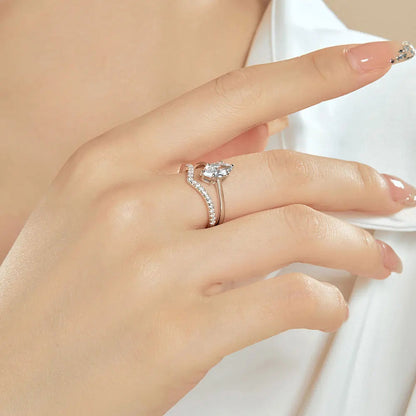 Bague duo de fiançailles en or blanc et diamants synthétiques portée au doigt d'une femme vue de côté.