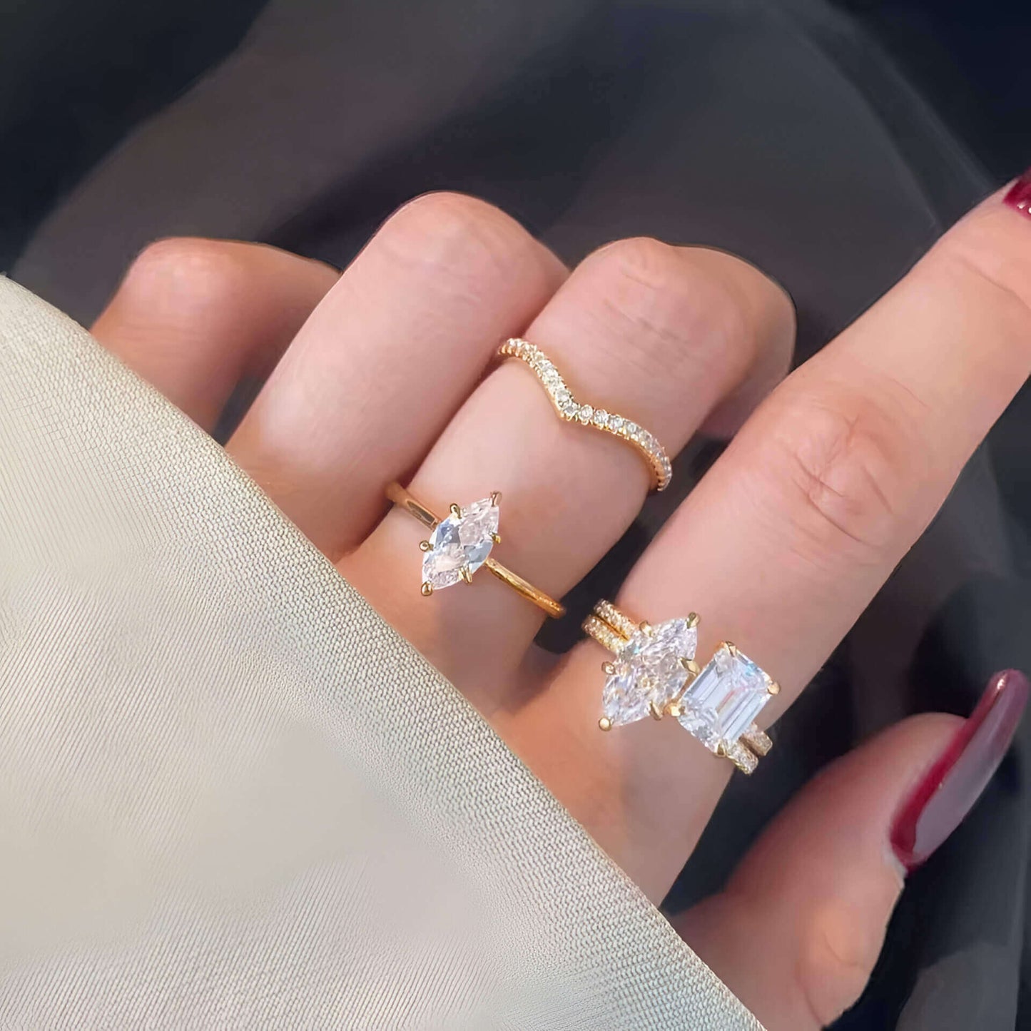 Bague duo de fiançailles en or jaune et diamants synthétiques portée au doigt d'une femme.