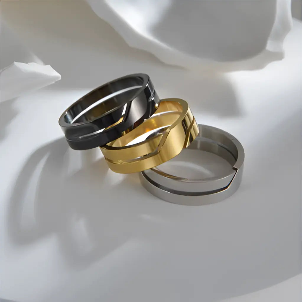 Bague en acier inoxydable variantes jaune, blanc et noir posées l'une sur l'autre.
