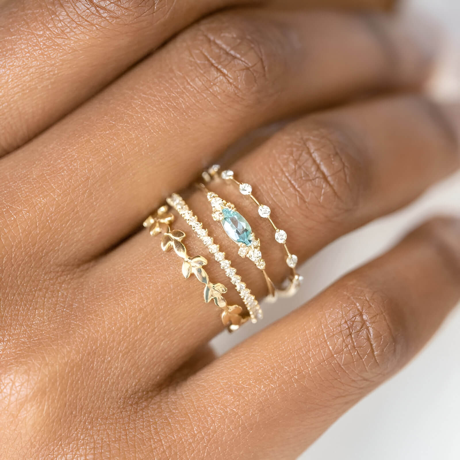 Bague fantaisie en or jaune et oxydes de zirconium portée au doigt d'une femme.