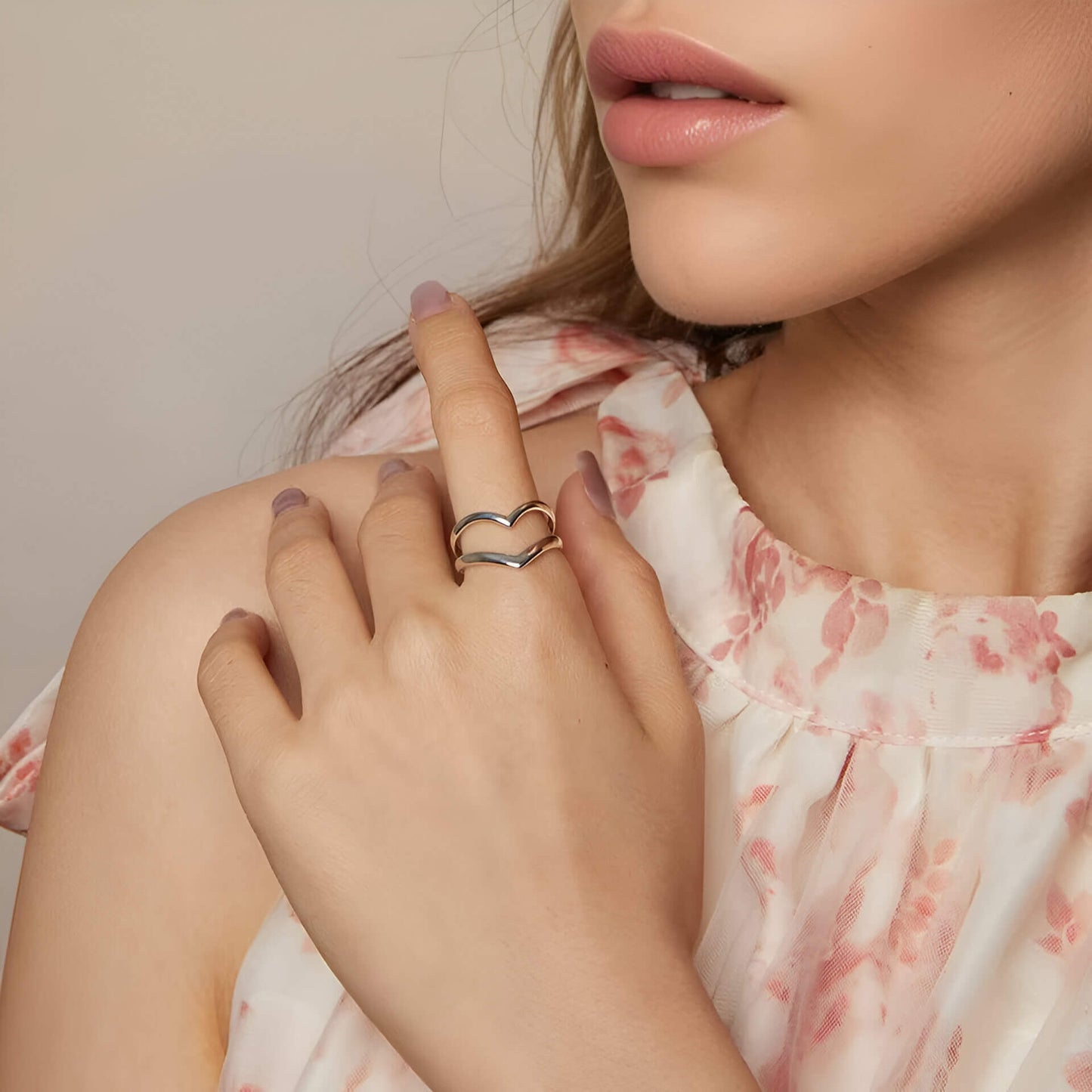 Bague fantaisie ouverte en or blanc portée au doigt d'une femme.