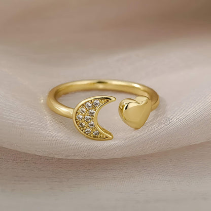 Bague fantaisie ouverte cœur et croissant de lune en acier inoxydable et or jaune sertie de diamants naturels vue de face.