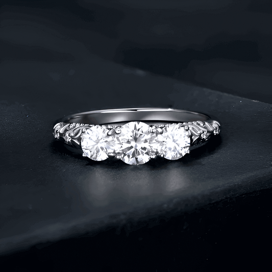 Bague trilogie triple diamants à plat vue de face sur surface noire.