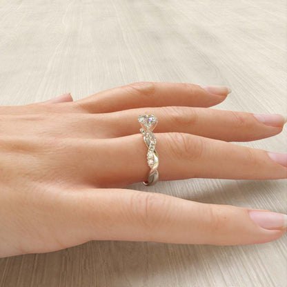 Vue latérale de la bague de fiançailles en argent tressée sur le doigt d'une femme, avec zircon cubique et plaquage or blanc 18K - La Petite Rebelle.