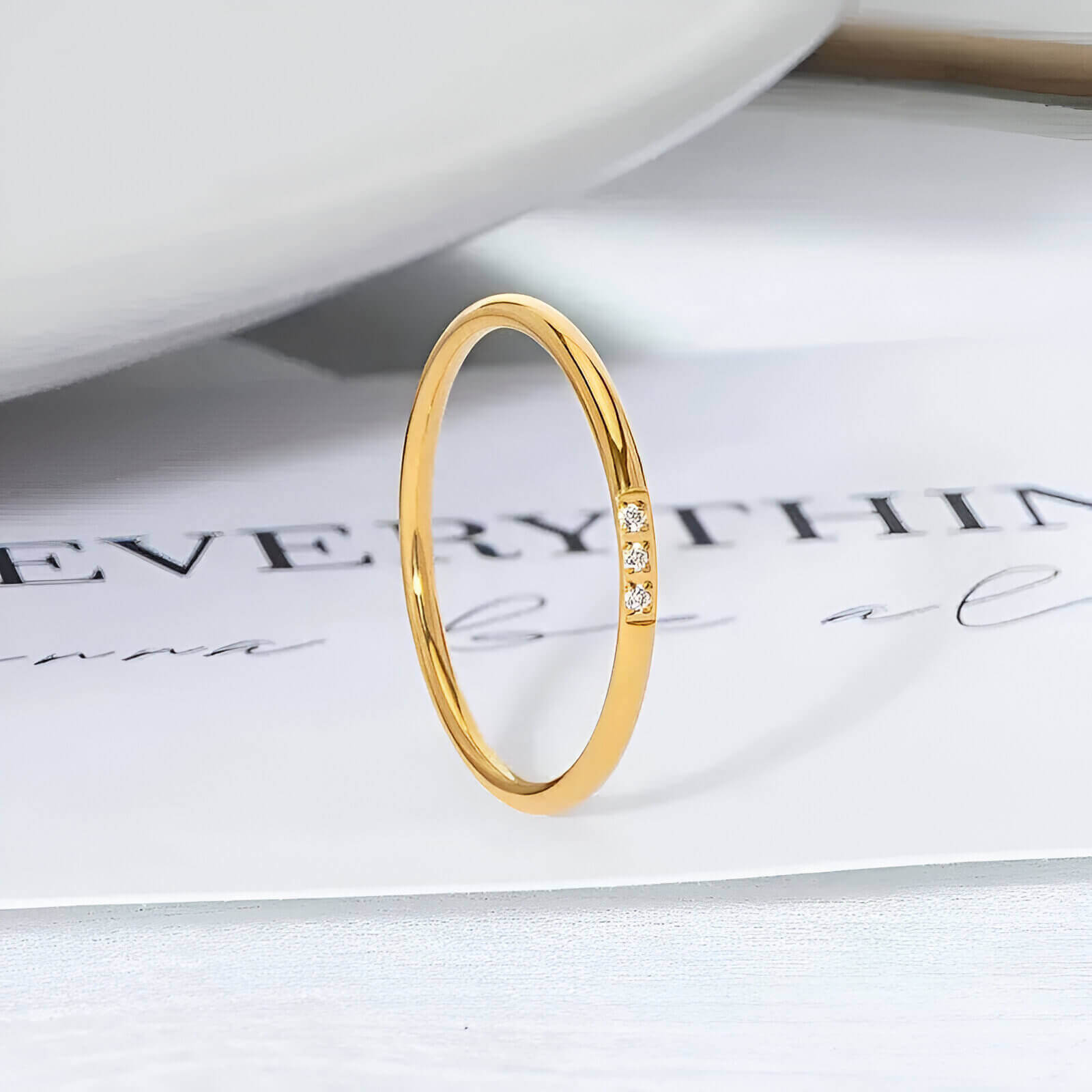 Variante 3 pierres de la bague fine 1mm Cassiane en acier inoxydable plaqué or jaune 18K et oxyde de zirconium vue de proche.