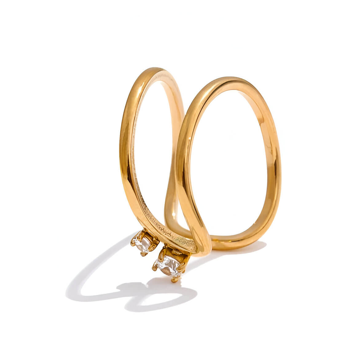 Bague fine courbée Spinela en acier inoxydable plaqué or jaune 18K et oxydes de zirconium sertis quatre griffes vue de proche.