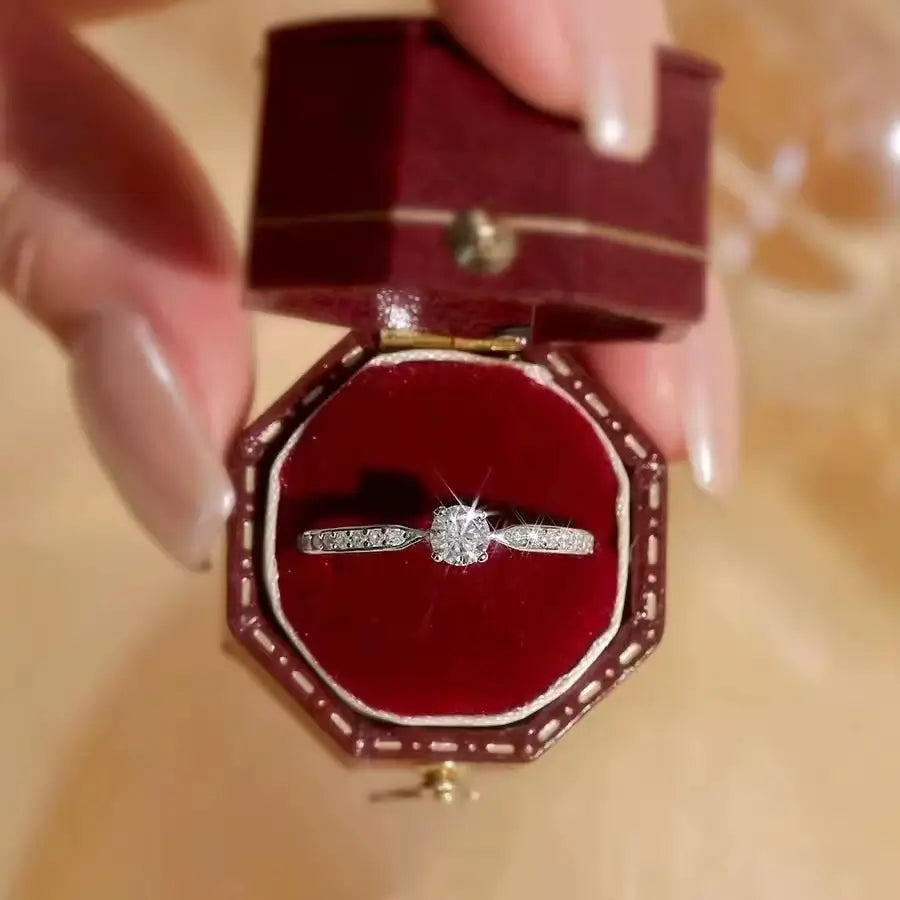 Bague fine de fiançailles serti griffes Thot en argent 925 plaqué or blanc et diamants étincelants rangée dans son écrin vue du dessus.