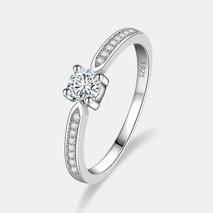 Bague fine de fiançailles serti griffes Thot en argent 925 plaqué or blanc et diamants sur fond blanc cassé.