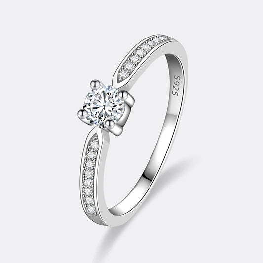 Bague fine de fiançailles serti griffes Thot en argent 925 plaqué or blanc et diamants sur fond blanc cassé.