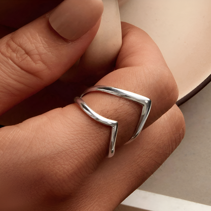 Bague incurvée ajustable en argent 925 plaqué or blanc délicat portée au doigt d'une femme vue de proche.
