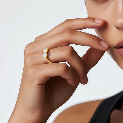 Bague nœud papillon en or jaune et diamants synthétiques portée au doigt d'une femme.
