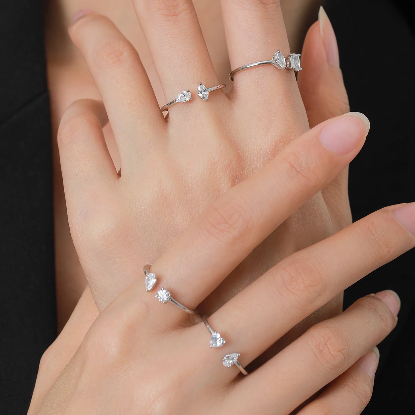Doigt de femme portant la bague ouverte en argent sterling 925 éclats perpendiculaires, avec diamants en zircon et finition or blanc 18K. Accessoire chic et tendance