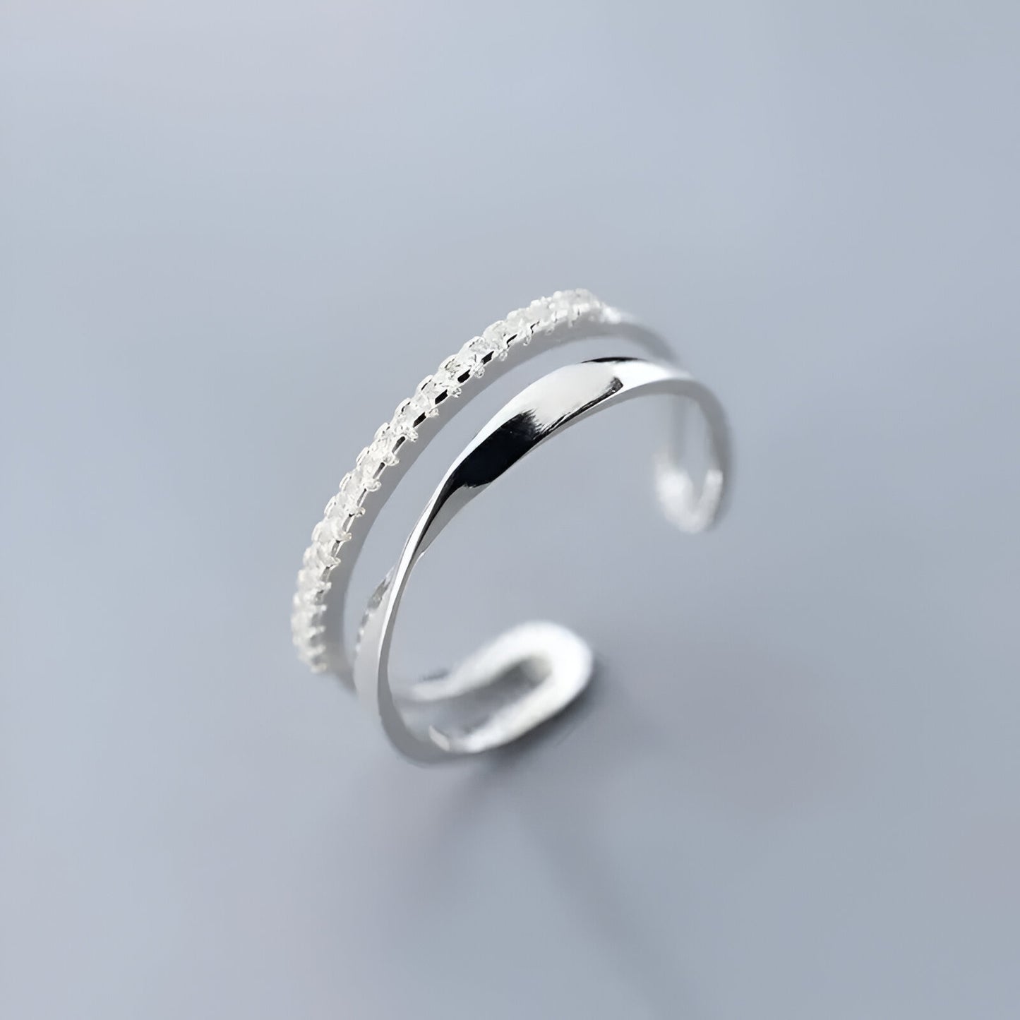BAGUE OUVERTE EN ARGENT DEMI-MÖBIUS ÉCLATS DE ZIRCON - Détail élégant de la bague ouverte en argent 925, avec son design moderne, mettant en valeur la courbure et la brillance des zircons en or blanc 14K - La Petite Rebelle.