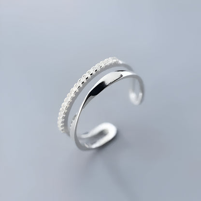 BAGUE OUVERTE EN ARGENT DEMI-MÖBIUS ÉCLATS DE ZIRCON - Détail élégant de la bague ouverte en argent 925, avec son design moderne, mettant en valeur la courbure et la brillance des zircons en or blanc 14K - La Petite Rebelle.