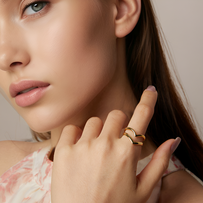 Bague ouverte courbée Cyrilla en argent 925 plaqué or jaune brillant portée au doigt d'une femme vue de proche.