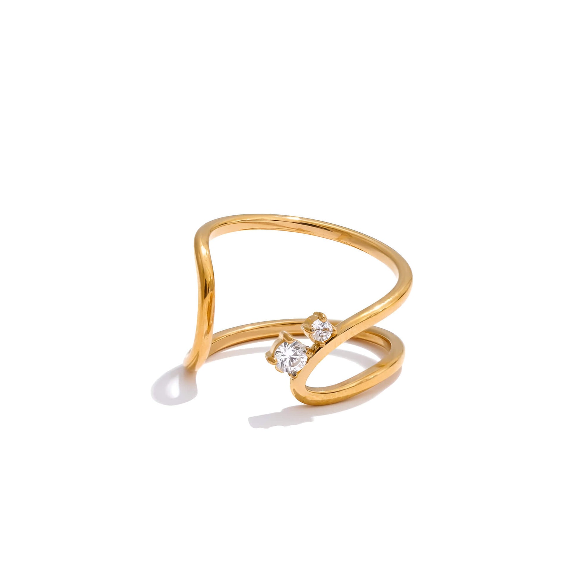 Bague ouverte courbée en acier et or jaune sertie d'oxydes de zirconium sur fond blanc.