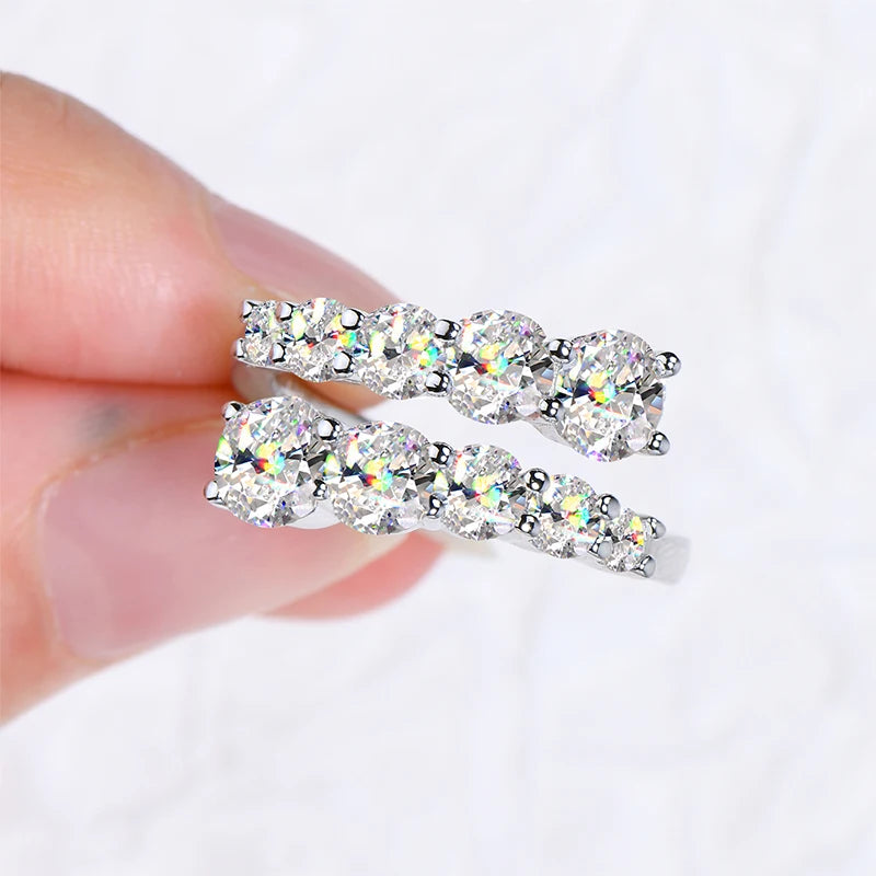 Bague ouverte dix diamants scintillants Pandora en argent 925 plaqué or blanc montrée entre les doigts d'une femme vue de proche.