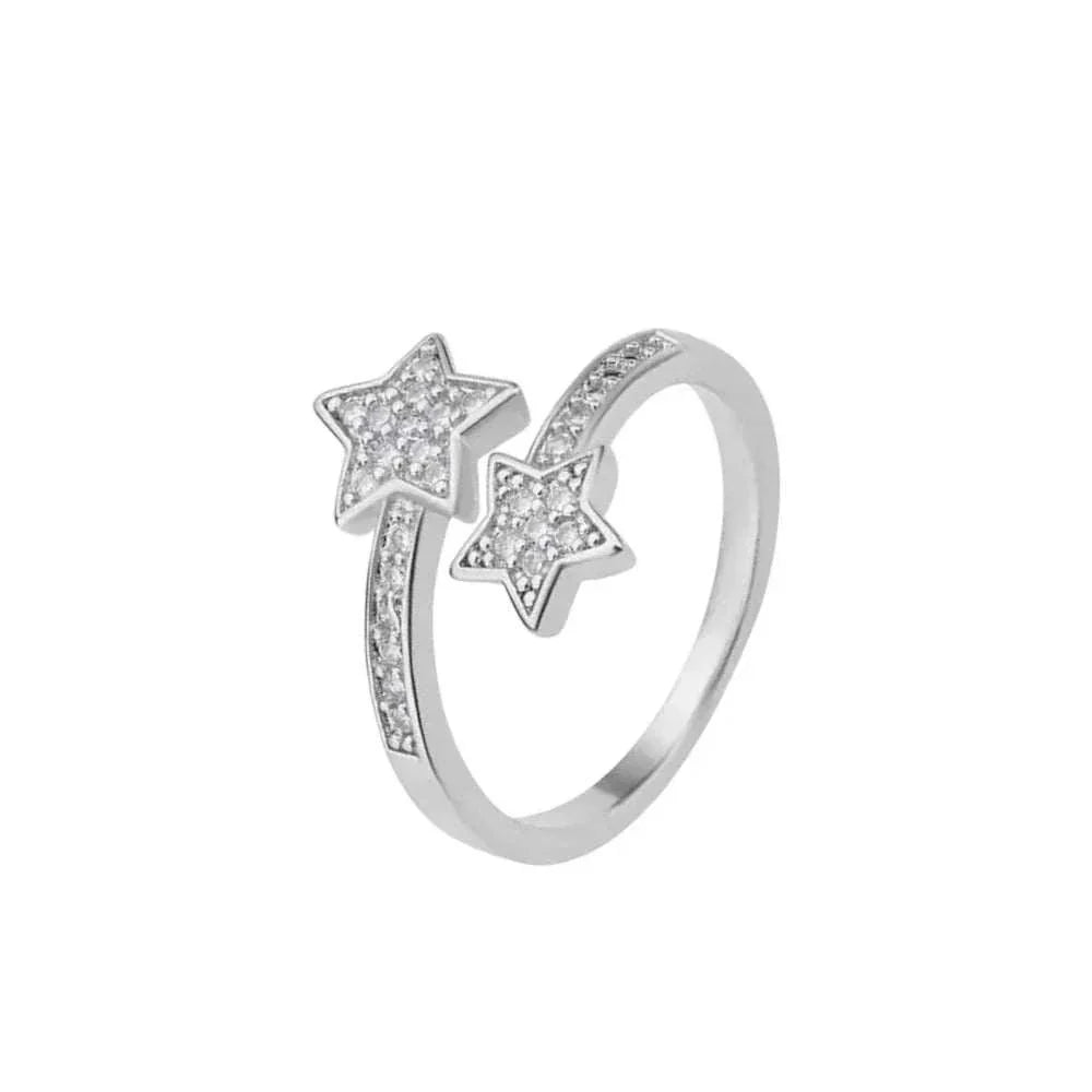 BAGUE OUVERTE EN ARGENT ÉTOILES FILANTES debout, brillamment décorée de zircons, en acier inoxydable plaqué or blanc 18K. Élégance et modernité.