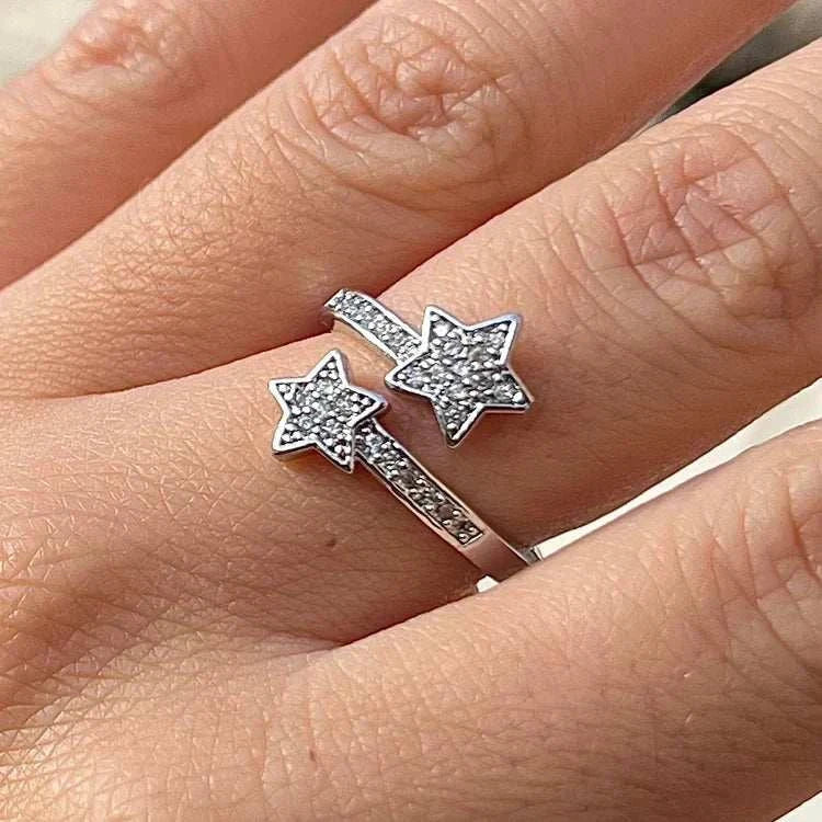 BAGUE OUVERTE EN ARGENT ÉTOILES FILANTES portée par une femme, design ouvert et éclat de zircons, ajoutant une touche de lumière et de féminité.