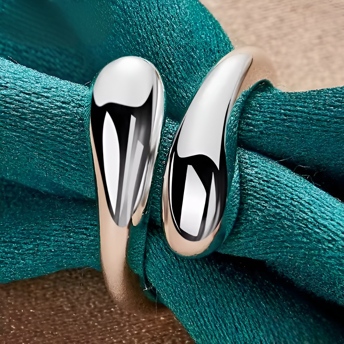 Détail de la bague ouverte en argent goutte d'eau sur nappe bleue cyan, mettant en valeur la brillance et l’élégance du plaquage or blanc 14K. Parfait pour toute occasion spéciale ou un usage quotidien - La Petite Rebelle
