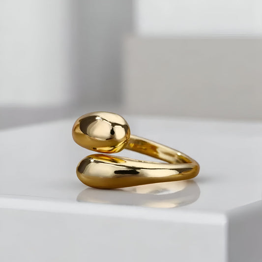 Bague ouverte en or 14K femme, modèle Goutte d'eau, sur socle blanc. Design épuré et chic avec un plaquage or 14K, parfaite pour un look minimaliste et élégant.