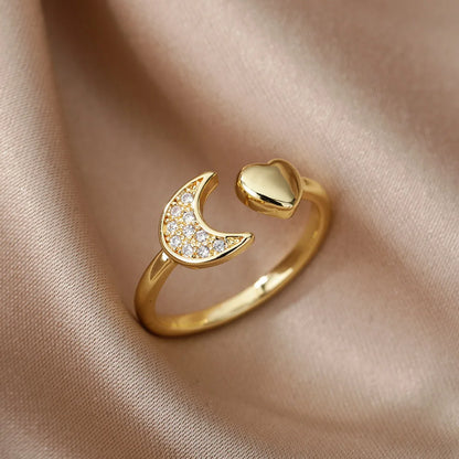 Bague ouverte en or 18K en forme de cœur et croissant doré avec zircons, élégamment posée sur un drap – bijou chic et symbolique