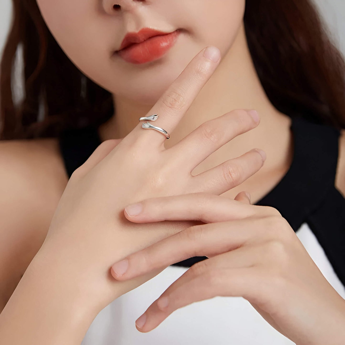 Bague fantaisie ouverte enlacement en argent 925 et or blanc portée au doigt d'une femme.