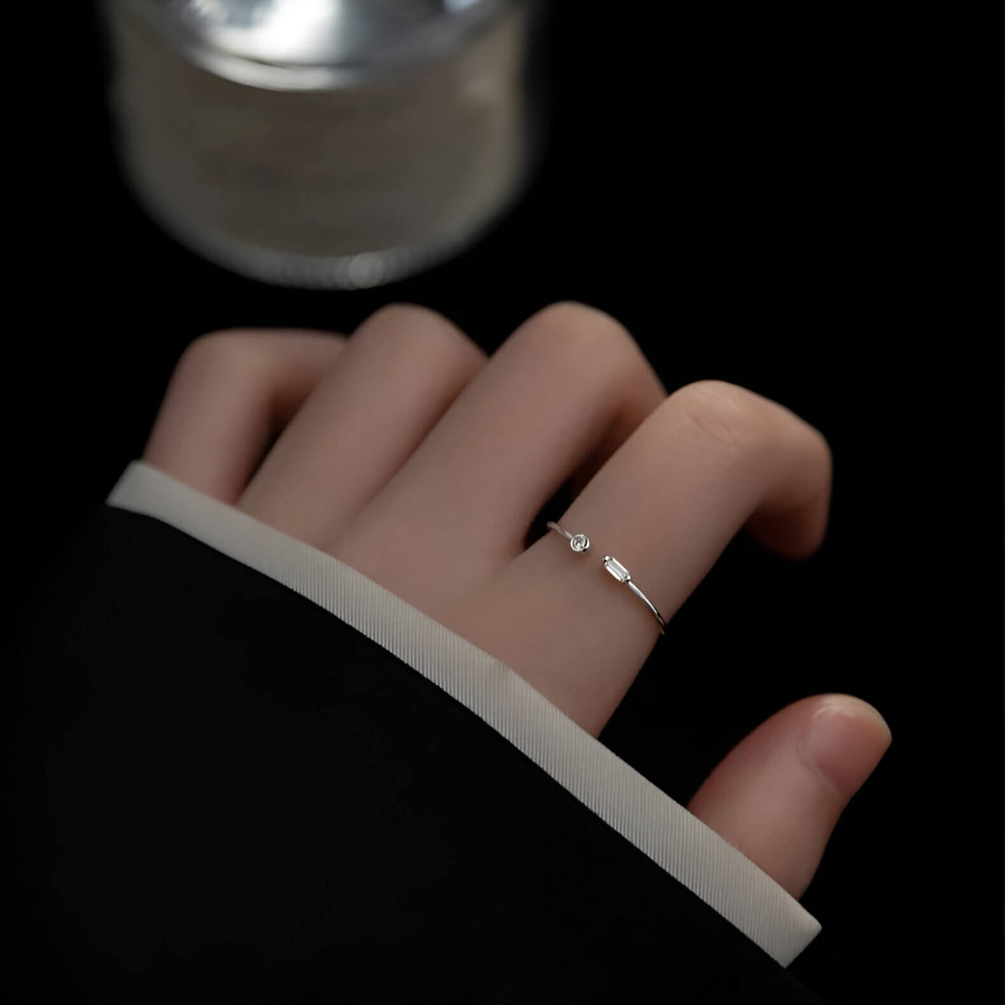 Bague ouverte fine de fiançailles Petrallis en argent 925 plaqué or blanc et diamants étincelants  portée au doigt d'une femme vue du dessus.