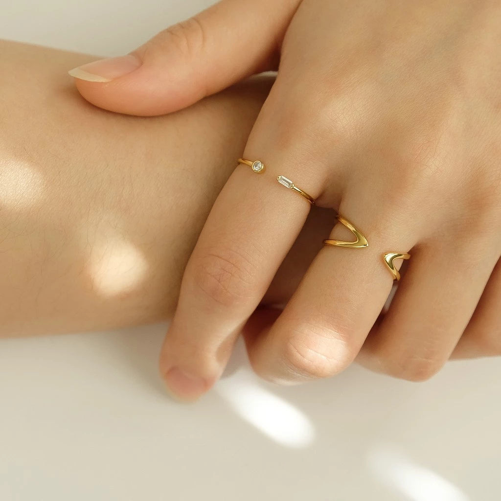 Bague ouverte fine de fiançailles Petrallis en argent 925 plaqué or jaune lumineux et diamants portée au doigt d'une femme vue de face.