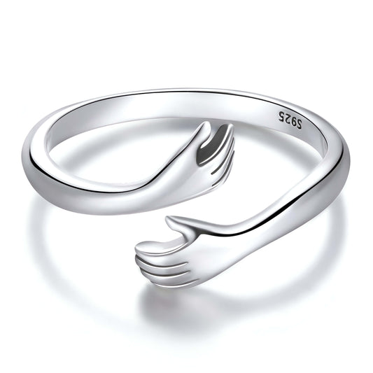 Bague ouverte main enlacée en argent 925 plaqué or blanc sur fond blanc.