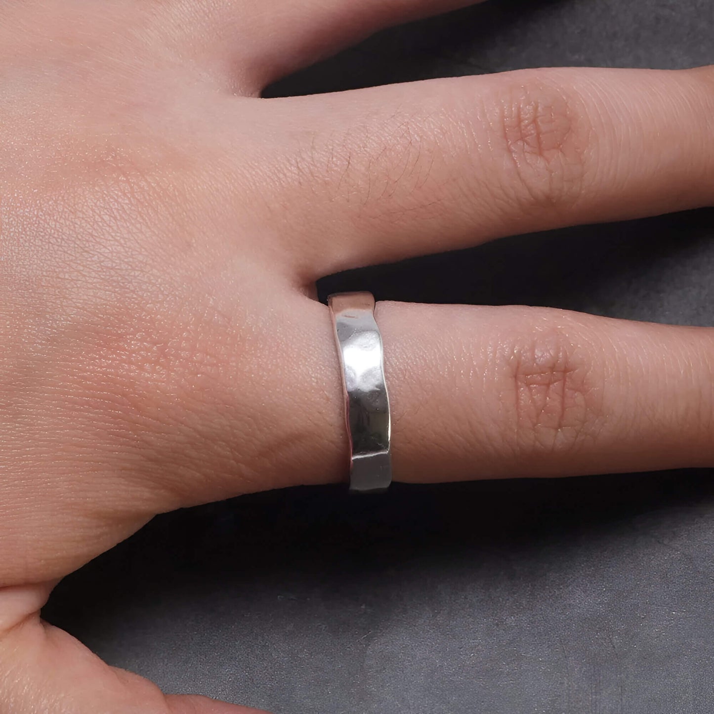 Bague ouverte martelée en argent 925 rhodié portée qu doigt d'une femme vue du dessus.