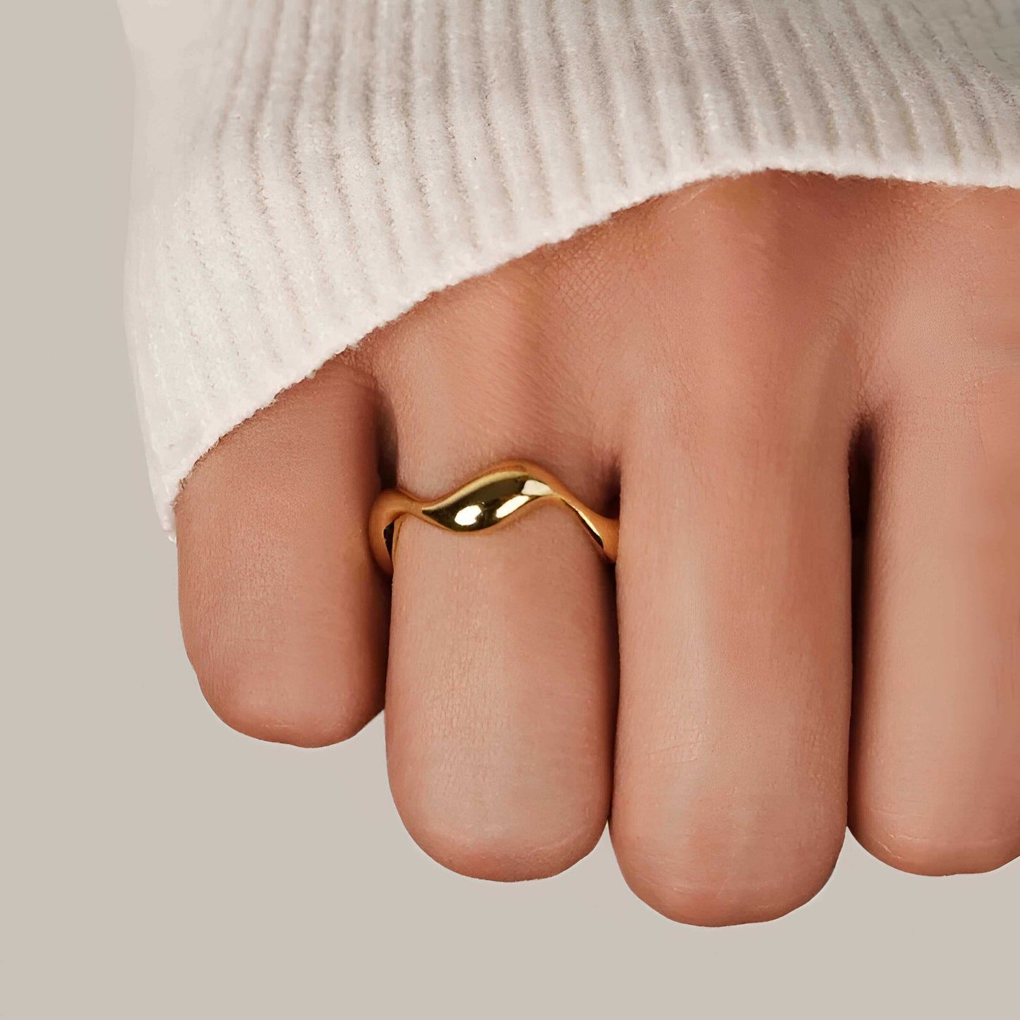 Bague ouverte ondulée Diana en argent 925 plaqué or jaune raffiné portée au doigt d'une femme vue de proche.