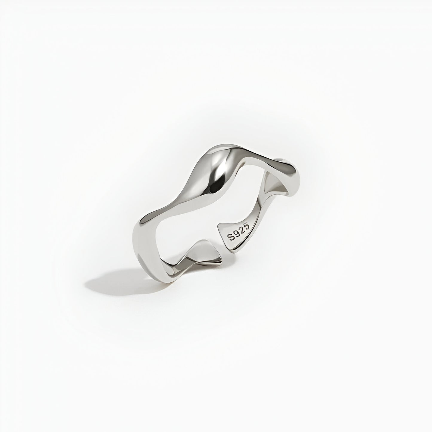 Bague ouverte ondulée en or blanc debout.