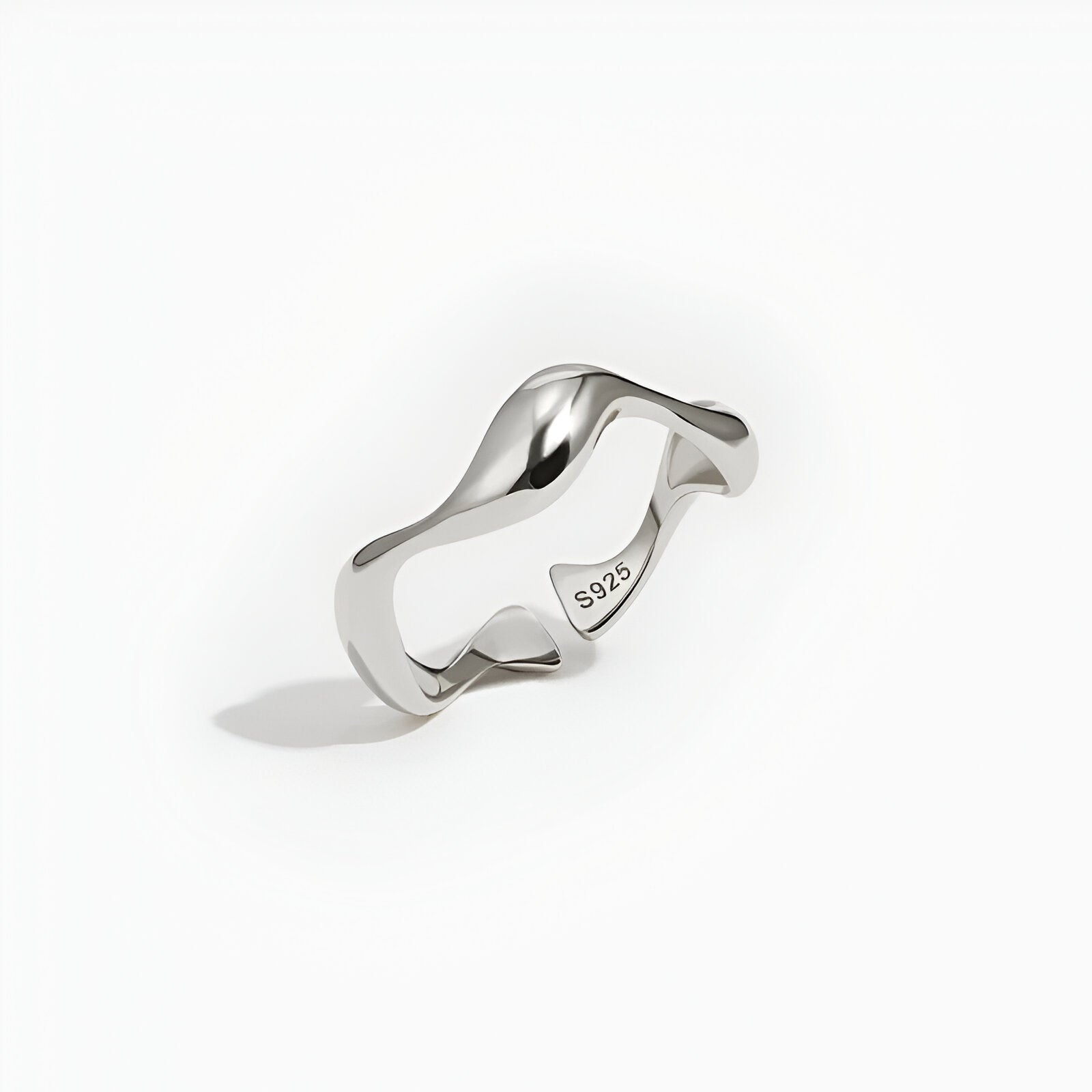 Bague ouverte ondulée en or blanc debout.