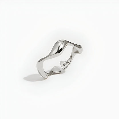 Bague ouverte ondulée en or blanc debout.