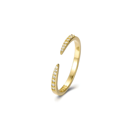 Bague ouverte pointe de diamants en or debout sur fond blanc.
